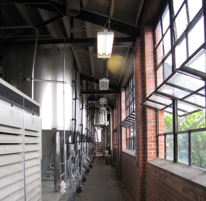 The fermenters are lined up at the back wall of the brewery. The building formerly housed the Goodwill Store.