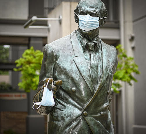 The bronze statue of former Greenville Mayor Max Heller, in downtown Greenville, personifies the mood of South Carolina and the nation with a medical mask on his face and another in his hand.
 