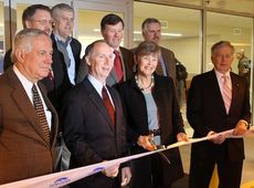 Dave Edwards (front, second from left), commissioners and executives representating firms that constructed the Rental Car Customer Center participated in the ribbon cutting Monday.
