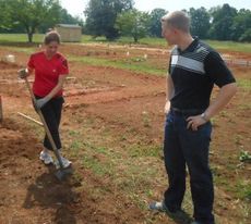 Michele Peek and Curtis Snyder were sharing information on their garden plots today. Michele was loosening some dirt and weeding. Curtis was discussing fertilization. 