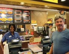 Ruth Ashmore tends to John Ashmore's order on the first day of the second year for Zaxby's on Wade Hampton Blvd. 