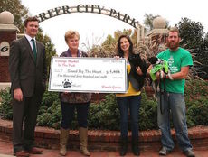 Wanda Garcia presented a donation to Jessica Monroe's non-profit Saved by the Heart, an organization working with stray and abandoned animals, at Greer City Park Thursday.
 