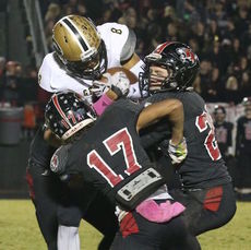 Evan Coffin (17) of Blue Ridge and his teammates stand up Chance Coleman of Greer.
 