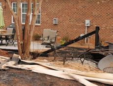 The melted fence, described by Fire Chief Chris Harvey, lays melted in front of backyard furniture that was scorched by last Wednesday's fire at Riverwood Farms.
 