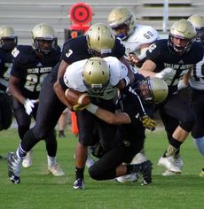 Quay Thackston (33) is tackled by Quantavious Cohen (3) and Ethan Alexander (14)