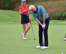 John O'Hurley putts as his wife, Lisa, watches in the background Saturday at Thornblade Club.
 