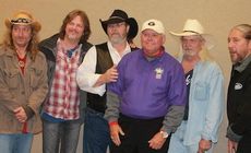 Rudy Painter, Family Fest executive director, (purple shirt) joins the Marshall Tucker Band for a photo minutes after the band's performance was canceled.
