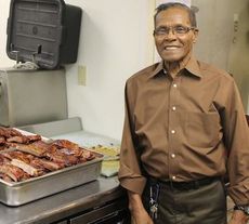 Fred Earle Jr. has a reason to smile. He just finished preparing 13 trays of his signature ribs, stacked 4-5 slabs high.
 
 
 