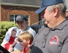 Greer Fire Chief Chris Harvey his two grandsons, James, 2, and Jackson Harvey, 4 months, with their father Dustin Strom.
 