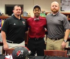 Datavious (Tay) Jenkins is flanked by head coach Shane Clark, left, and coach Jarrod Moore after signing with Lenoir-Rhyne University.
 
 