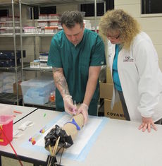 Scott Perry, veteran and scholarship recipient, learns phlebotomy skills at Greenville Technical College from Rhonda Anderson.
 
 