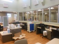 The glass-enclosed nurses station provides a wide view to monitor patients.
