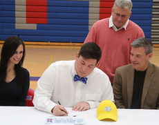 Dan VonWaldner signed to play football at Limestone College. Left to right: Karen VonWaldner (mother), Don, Stephen VonWaldner (father). Todd Smith peers over Dan's shoulder during the signing ceremony.
 