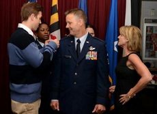 Kelly’s wife, Kristi looks on, as son, Grant, pins his one star rank signaling the rank of Brig. General.