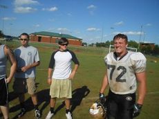Alex Waters (72) gets a visit from  Luke Howell (center) and Derrick Davis, last year seniors.