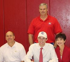 Golf coach Sam Oates joins Will Strickland and his parents at the signing ceremony.
 