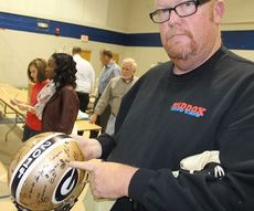 Chris Tapp points to the signature of his son, Adam, on the helmet.
 