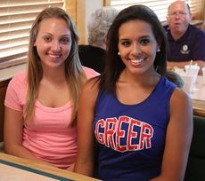 JV cheerleader Carley McCall, left, and Brooke Freeman, of the varsity squad, work the inside of the restaurant.