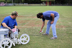 Donny Pittman, left, and A.J. Austin begin work on the Tigers' midfield logo.
