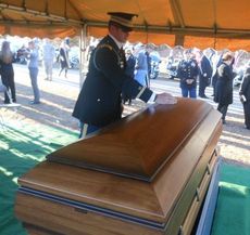 A commemorative coin is laid atop Sgt. Hicks' casket as the last military rite in today's funeral.