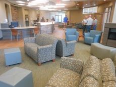 The waiting area provides single and multiple seating options across from the stone-built visitor's and check-in desk.