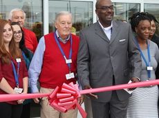 Patrick Doyle (red sweater) was designated to cut the traditional red ribbon officially marking the grand opening of a Kohl's store.
 