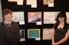 Jake Baynes, left, and Madison Frederick stand next to their winning artwork in the competition 
