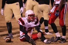 A Clinton player sits on the field while surrounded by Greer defenders.
 