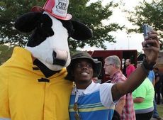 Dru Gadson, who tied for eating a sandwich fastest, takes a selfie with the Chick-fil-A mascot.
 