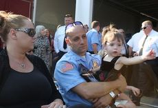 Phil and Angela Mistrulli-Cantone, with their daughter Adriana, 2, observe the 9/11 Memorial ceremony Wednesday at the Boiling Springs Fire Department. Phil was a fireman in Long Island who responded to the call at the World Trade Center on 9/11. Angela's father was killed while working at Windows on the World.