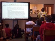 Chris Kabali talks to students at Riverside Middle School about Uganda.