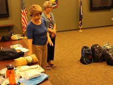 Marsha Lee, front, and Karen Moose are filling book bags for greater Greer homeless in need of necessities.