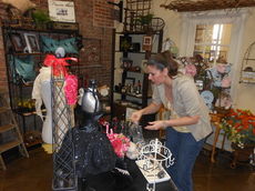Carrie Flanagan puts some finishing touches at her boutique Friday at The Grapevine. She is among the 40 businesses that have leased space at the store on 211 Trade Street.