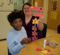 Washington Center student Breanna Sales and her Para-educator assistant Cala Cater display a fall door hanger craft project to celebrate the season.