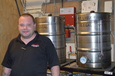Jon Aylestock, the brewmaster for Wild Ace Pizza and Pub, stands in front of some of his brewing equipment.
 