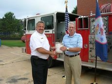 Steve Kovalcik, left, Fire Chief, City of Greenville, gives vehicle titles to Philip Hill, Assistant Dean of Technologies at Greenville Technical College.
 