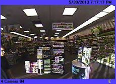 The suspect is viewed coming into the frame from the left at Game Stop.