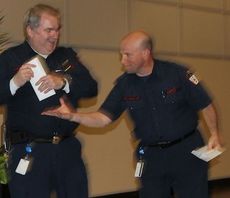 Fire Chief Chris Harvey, left, and Fire Marshall Scott Keeley play keep away with prizes they won at the Public Safety Officer's dinner Thursday night.