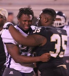 Raymond Booker consoles an Emerald player. Greer beat Emerald, 34-30, in the first round of the Class AAA playoffs Friday.