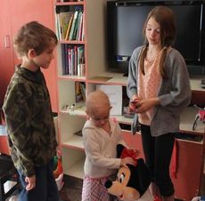 Lilly Clark, middle, is the center of attention today at the Ronald McDonald House Charities in Greenville. J.D. and Kate, her brother and sister, enjoyed the afternoon in the playroom.