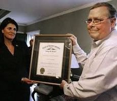Associated Press reporter Jim Davenport receives The Order of the Palmetto, South Carolina's highest civilian honor, from S.C. Gov. Nikki Haley at his home in Columbia. South Carolina Associated Press reporter Jim Davenport has died. He was 54.