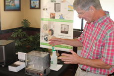 Larry Beheler demonstrates how the air purifier clears smoke.
 