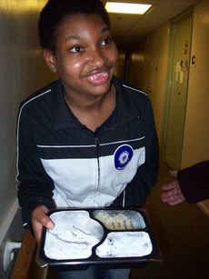 Washington Center student Britney Herbert delivers a hot meal as a volunteer for Meals on Wheels Greenville. 