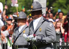 Lt. Derrick Gamble, of the South Carolina Highway Patrol Honor Guard, takes the folded and rolled up 4-foot flag to Allen Roberson, director of the Confederate Relic Room and Military Museum.
 