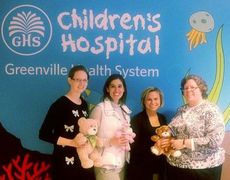 On behalf of Washington Center, teachers Samantha Stansell, Erin Sosebee, and Elizabeth Piper, left to right, deliver donated Teddy bears to Missie Townsend, far right, with the Children's Hospital of the Greenville Health System. These bears will be given to children before they go into surgery. 