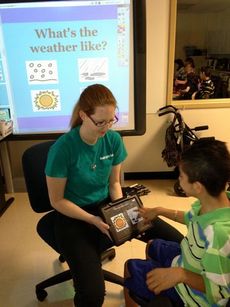 Washington Center student Kenny Diaz uses the Ipad to answer questions during circle time with teacher Samantha Stansell.