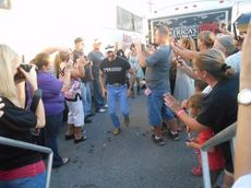 Aaron Tippin makes his way to the stage through a double line of officials, security and fans at the start of his concert tonight at the Greer Family Fest.