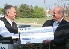 Tom Merritt, founder and President of Oobe, presents Darrin McDonald, BMW Charity Pro-Am executive director with a $75,000 check to add to the tournament's fundraising efforts.