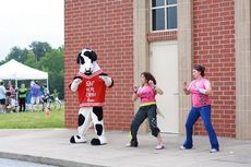 Zumba instructors warm up the walkers/runners along with the Chick-fil-A cow.