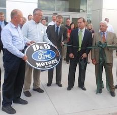 Skip and George Davenport, far right, respectively, observe the presentation of the D&D Motors sign that has been part of its business heritage.